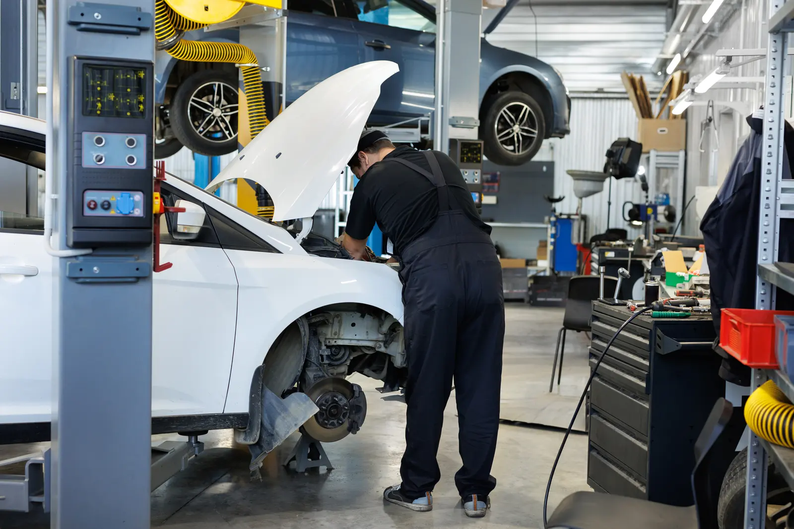 Technician working on a vehicle in an auto repair bay