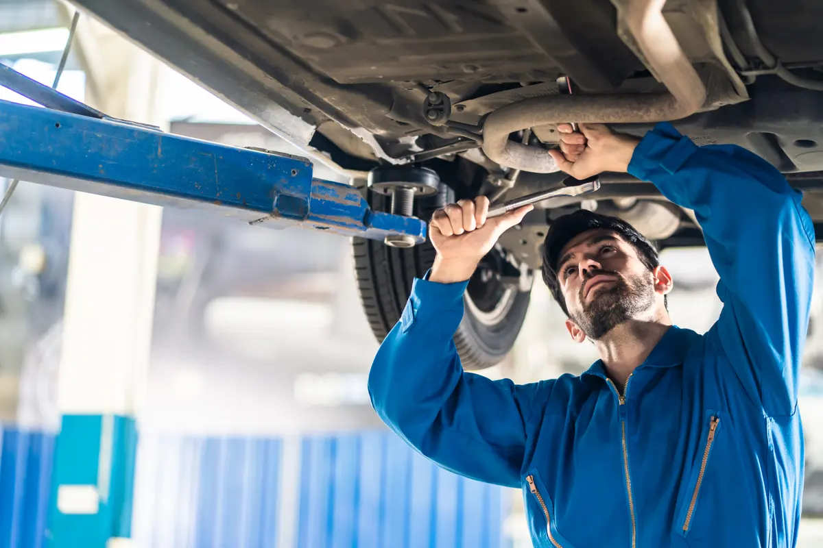 Mechanic servicing the underside of a vehicle